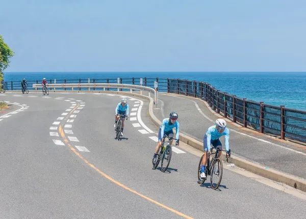 海沿いのカーブを並んで走るメンバー
